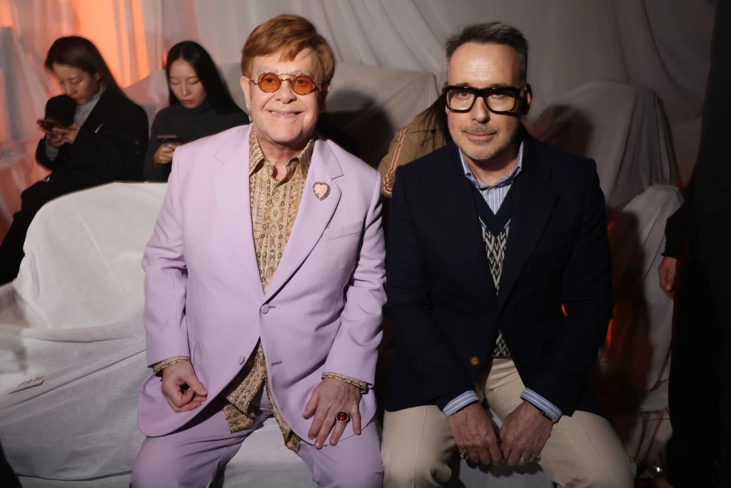 Férjével, David Furnish-sel nyáron, a párizsi divathéten. Elton zakójának hajtókáján ott a spéci bross