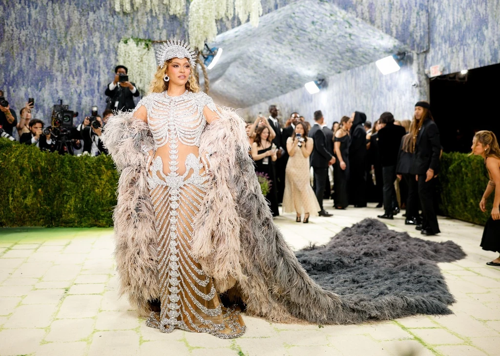 Beyoncé esetében sem hiányzott a nagyszabású belépő: gyémántosan csillogó-villogó csontvázként érkezett, méretes fejékkel és hosszú szőrmeuszállyal egészítve ki a szettet. A haláli ruha a francia diivattervező, Olivier Rousteing kezét dicséri 